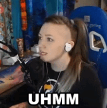 a woman wearing headphones and a ponytail is sitting in front of a microphone and says uhmm .