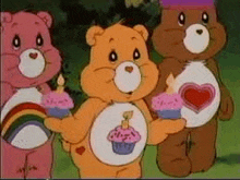 three care bears are holding cupcakes and a rainbow in their hands .