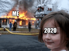 a little girl is standing in front of a burning house with the year 2020 on her forehead