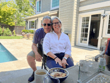 a man and a woman sit at a table with a bowl of food in front of them