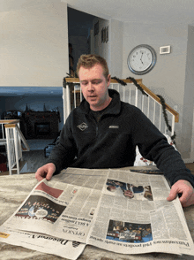 a man sitting at a table reading a newspaper that says opinion on it