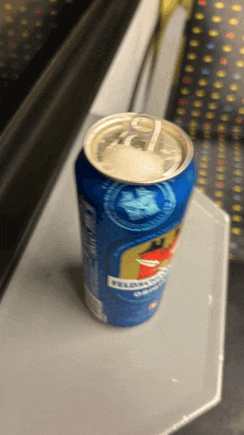 a can of pilsner beer sits on a grey table