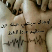 someone has a heartbeat tattoo on their wrist with arabic writing