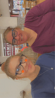 two women wearing glasses are standing next to each other in front of a sign that says ' 28m17 '