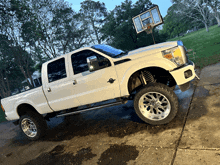 a white truck with a basketball hoop attached to the hood