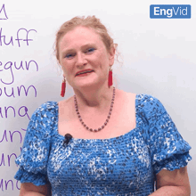 a woman stands in front of a white board that says " tuff " on it