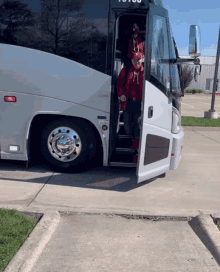 a man in a red hat is getting off a bus that says ' to you ' on the side