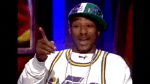 snoop dogg is wearing a hat and giving a thumbs up sign .