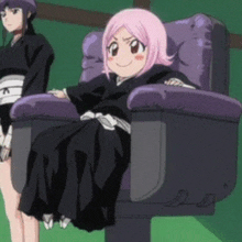 a girl with pink hair is sitting in a black chair