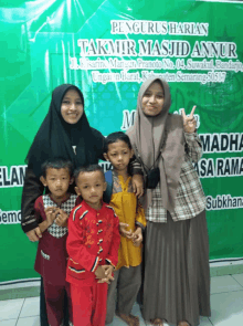 a group of people posing in front of a sign that says " pengusharian takmir masjid annu "