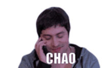 a man is talking on a cell phone with the word chao written on the screen .