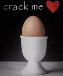 a brown egg in a white cup with the words crack me above it