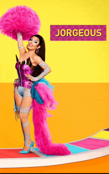 a woman in a colorful costume is holding a pink pom pom and a sign that says jorgeous