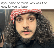 a man with curly hair and a beard wears a red and white scarf around his head