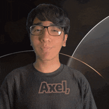 a young man wearing glasses and a black shirt with the word axel on it