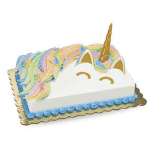 a cake decorated to look like a unicorn with a rainbow mane and horn