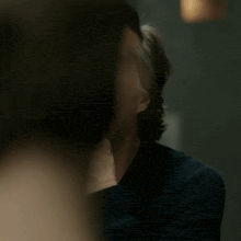 a man with his hand on his chin looks at the camera