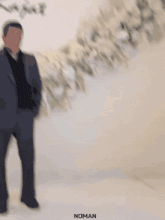 a man in a suit stands in front of a wall that says rita & rajat