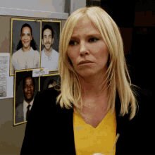 a woman stands in front of a bulletin board with pictures of people and a sign that says " teragers " on it