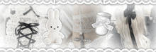 a black and white photo of a stuffed bunny a cross and a cup