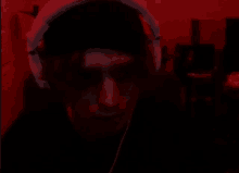 a man wearing headphones in a dark room with a red background