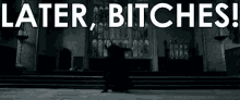 a black and white photo of a person standing in front of a sign that says later bitches