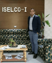 a man stands in front of a wall with the word iselco-i on it