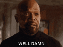 a bald man with a beard is making a funny face and saying `` well damn '' .