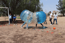 a group of people are playing a game of bubble soccer