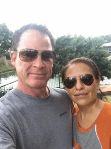 a man wearing sunglasses and a patagonia shirt poses with a woman