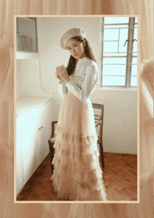 a woman wearing a ruffled skirt and a beret stands in front of a window