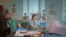 a woman sits at a desk in front of a computer with a sign on the wall that says " i cannot speak "