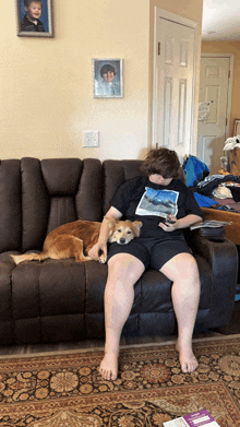 a boy is sitting on a couch with a dog on his lap