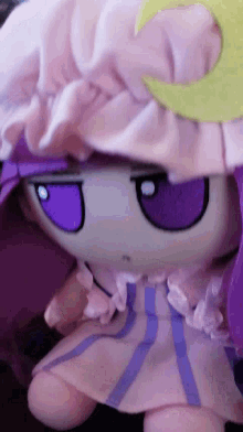 a stuffed animal with purple eyes and a purple skirt