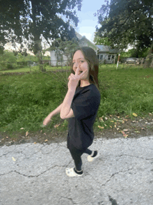 a girl wearing a black shirt and white crocs is walking down a street