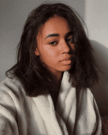 a woman taking a selfie with a white towel around her neck