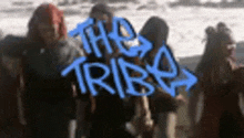 a group of people are standing in front of a sign that says the tribe