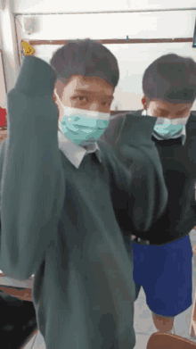 a boy wearing a mask is standing next to another boy wearing a mask .