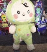 a green and white stuffed animal is standing in front of a sign that says gmm
