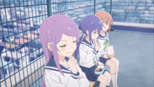 three anime girls are sitting in front of a fence