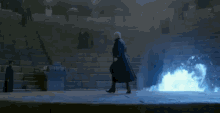 a man in a black coat is walking on a stage