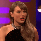 a woman wearing a black dress and a choker necklace looks surprised