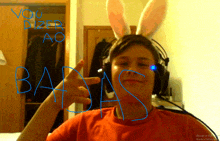 a boy wearing bunny ears is giving a thumbs up and has the word bastas written on his face