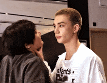 a man wearing a white shirt that says " enfants " on it