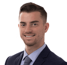 a man in a suit and tie smiles at the camera