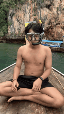 a shirtless man is sitting on a boat wearing a mask and goggles