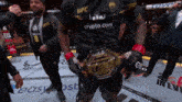 a man wearing a black ufc shirt holds a gold belt