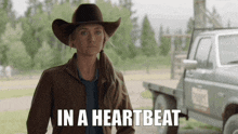 a woman in a cowboy hat stands in front of a truck with the words in a heartbeat above her