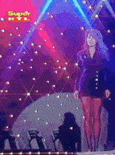 a woman stands on a stage with a super rtl logo in the background
