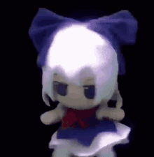 a stuffed doll with white hair and a blue bow is dancing .